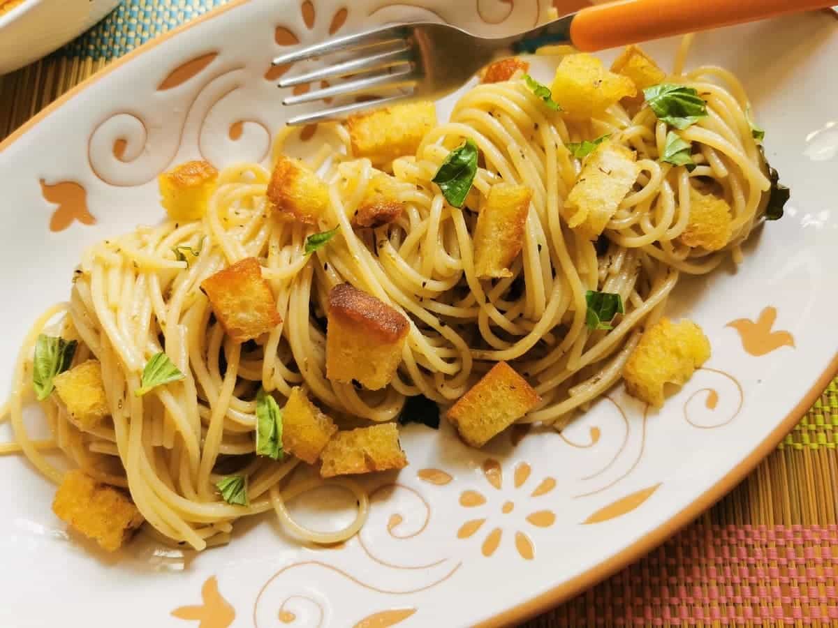 Anchovy spaghetti from Naples on a plate with a fork.