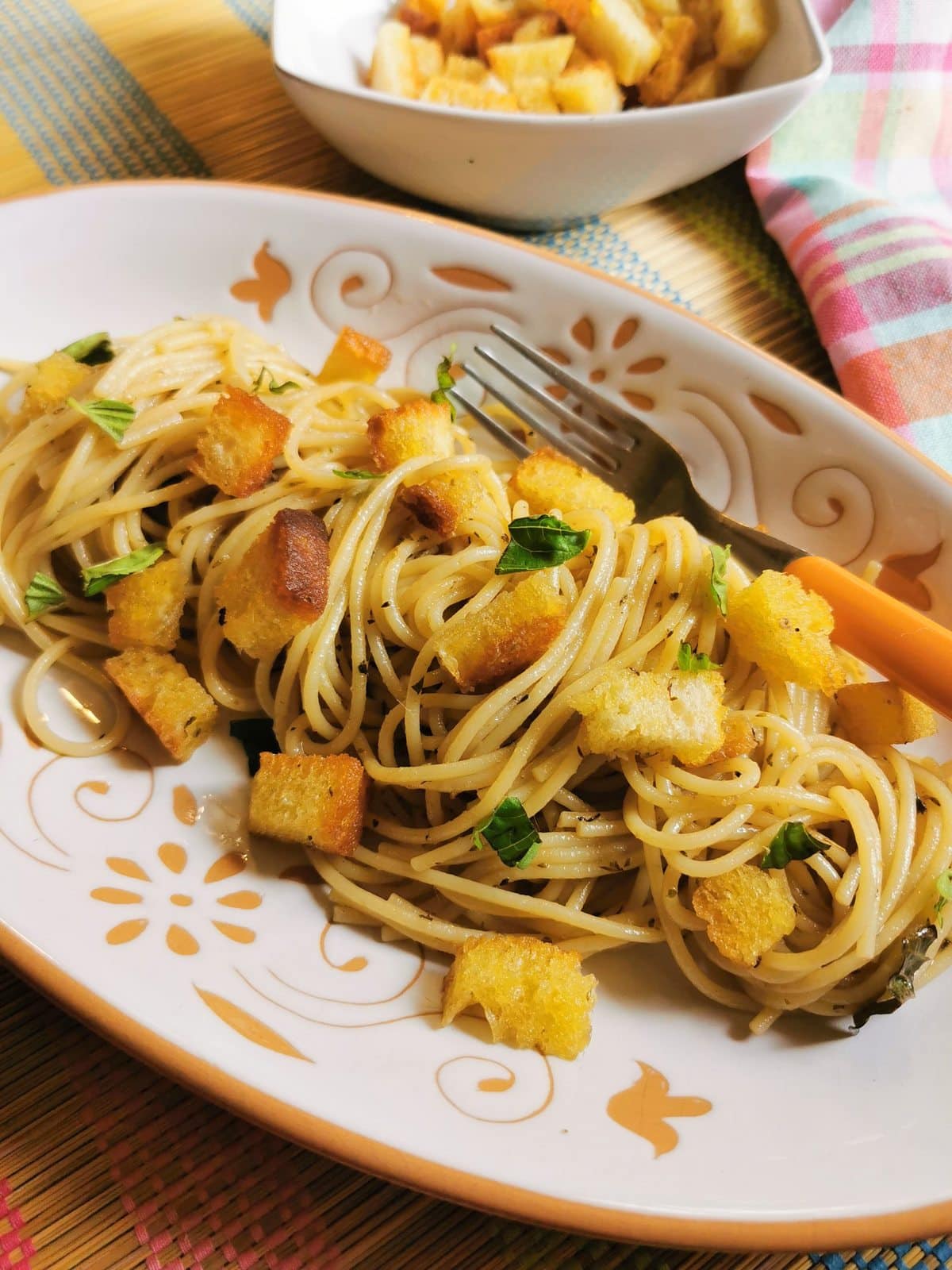Anchovy pasta from Naples (spaghetti alla Gennaro) garnished with croutons. 