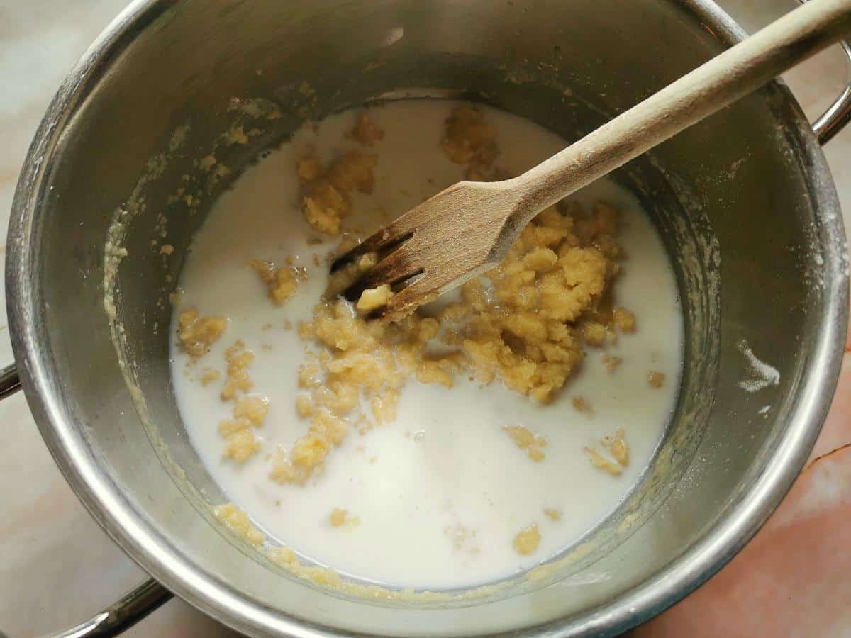 Milk added to roux in saucepan.