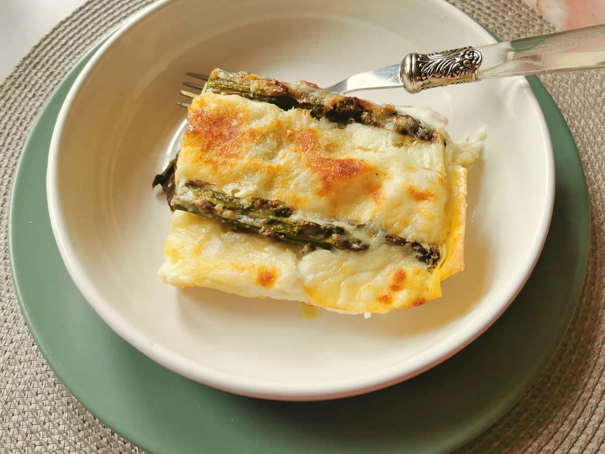 One serving of asparagus lasagna in a white bowl.