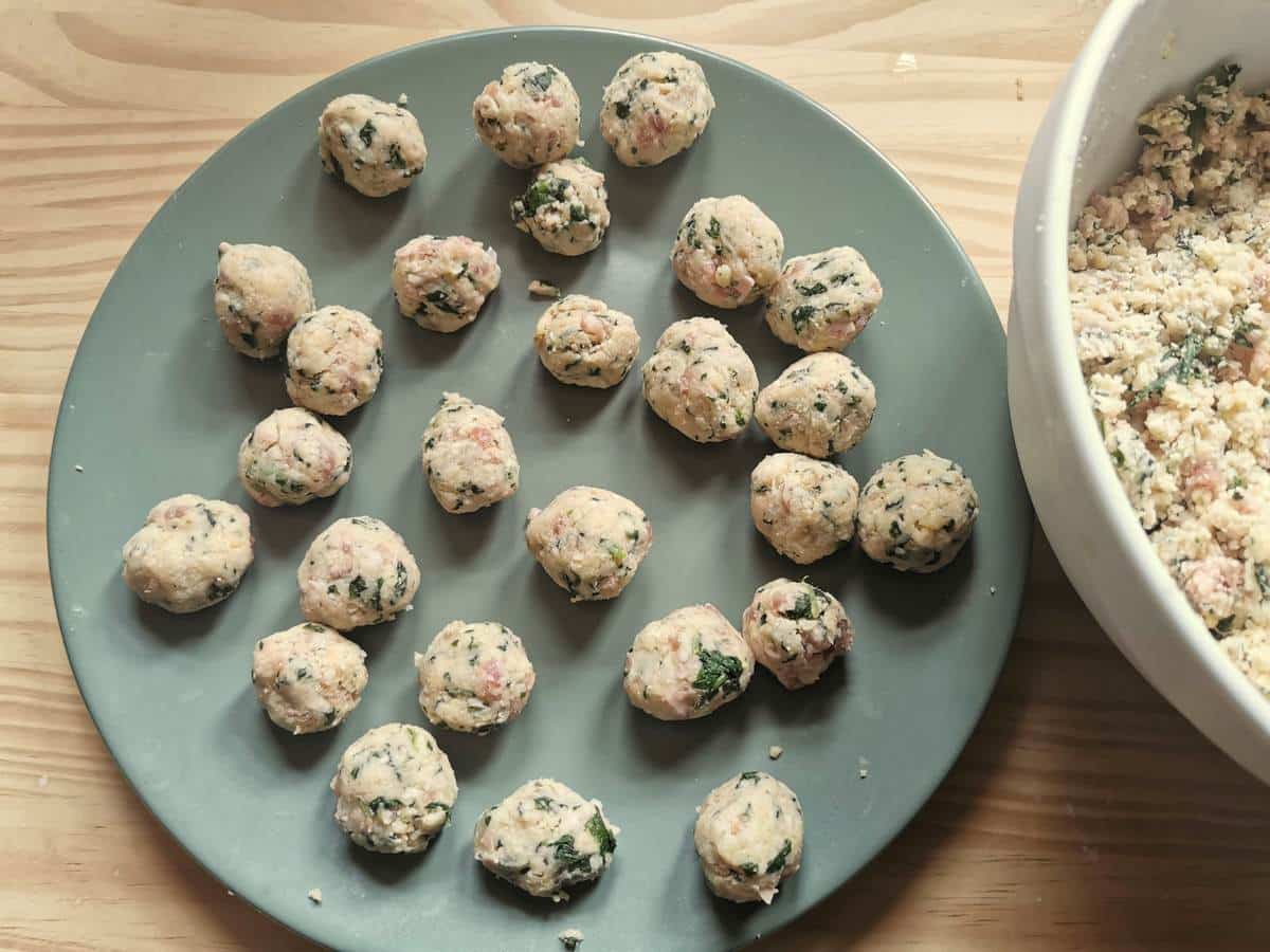 Balls of casoncelli filling on a green plate.