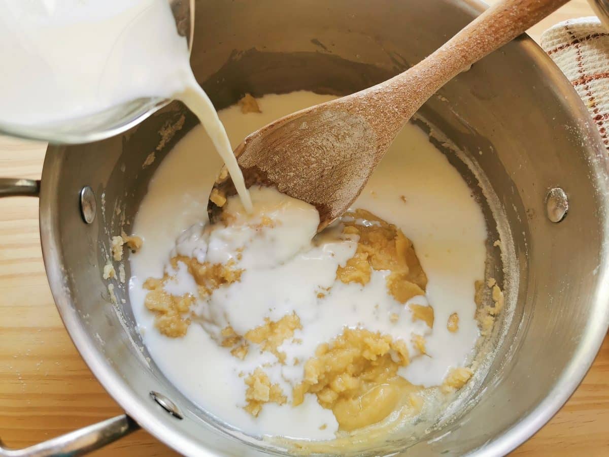 Milk being mixed with a roux.