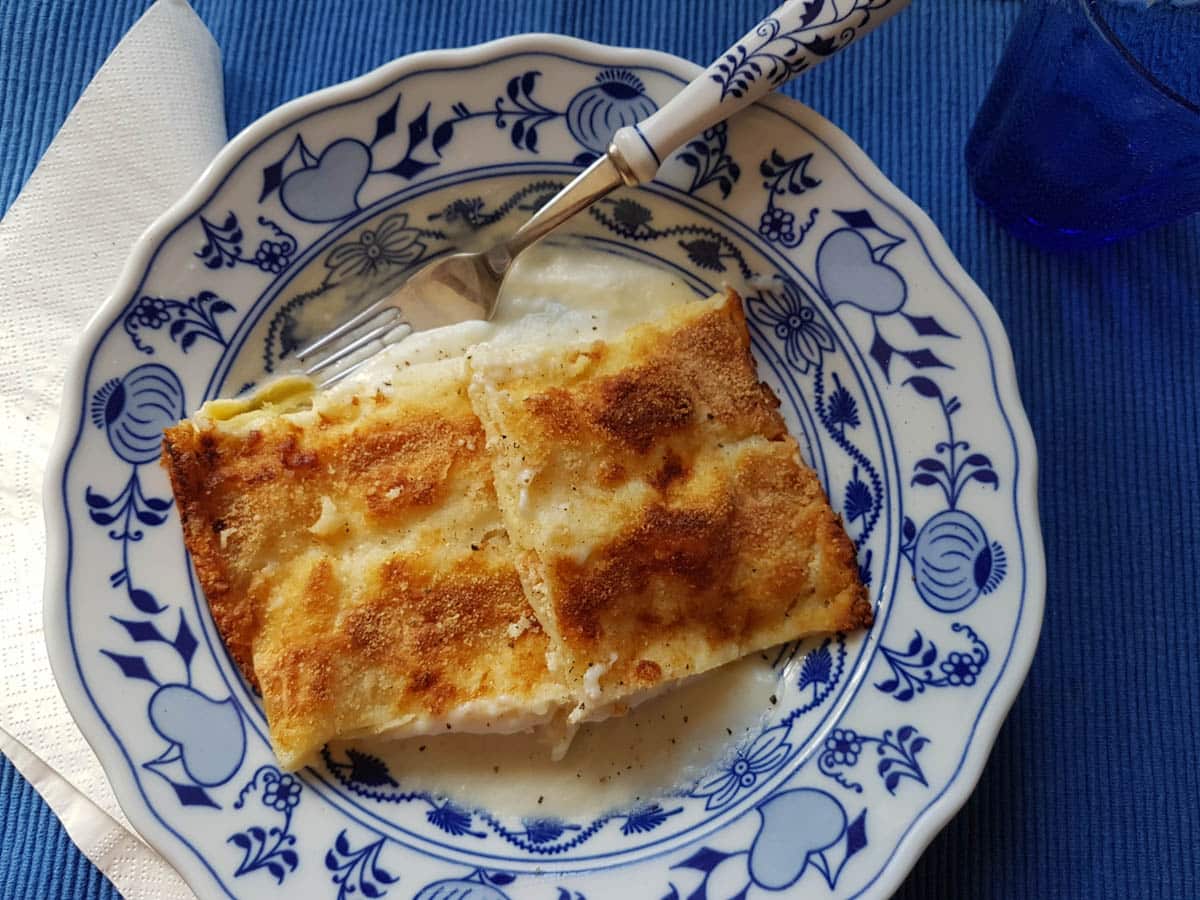 Homemade smoked salmon cannelloni in blue and white bowl.