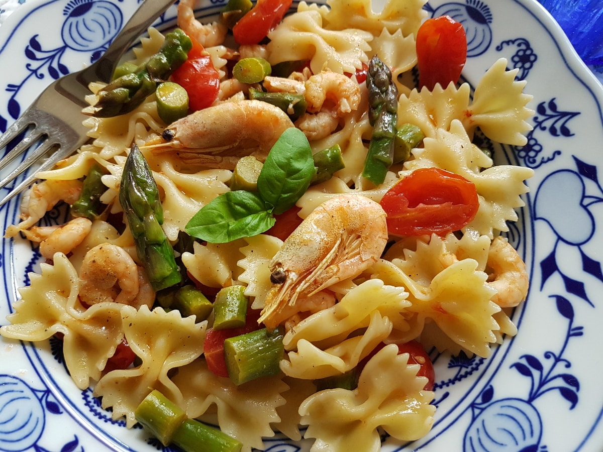 Italian shrimp and asparagus farfalle in blue and white bowl.
