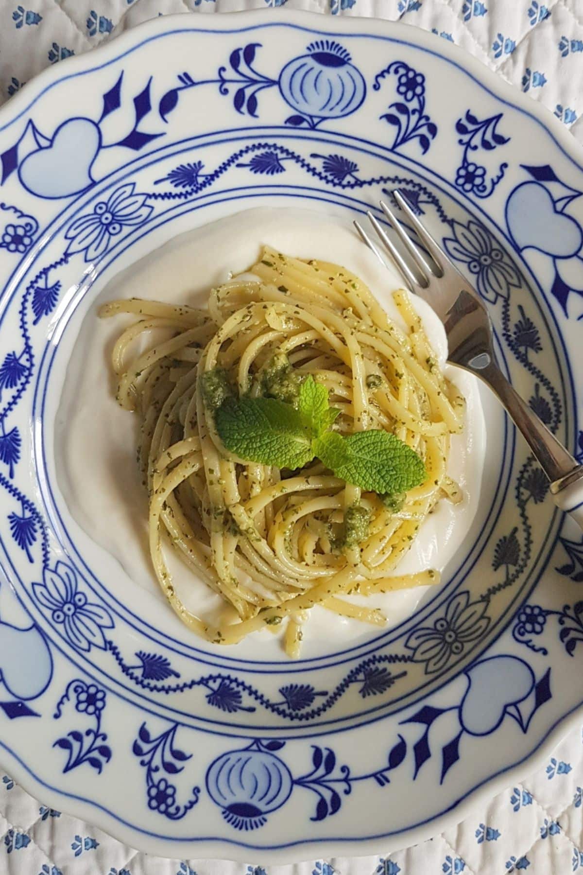 Linguine with mint pesto and ricotta cream garnished with mint leaves.