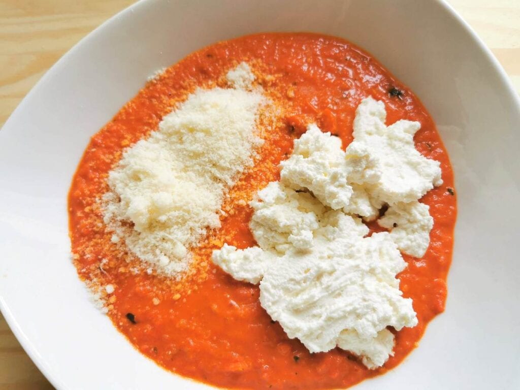 Mixing in ricotta and pecorino into the pesto calabrese. 