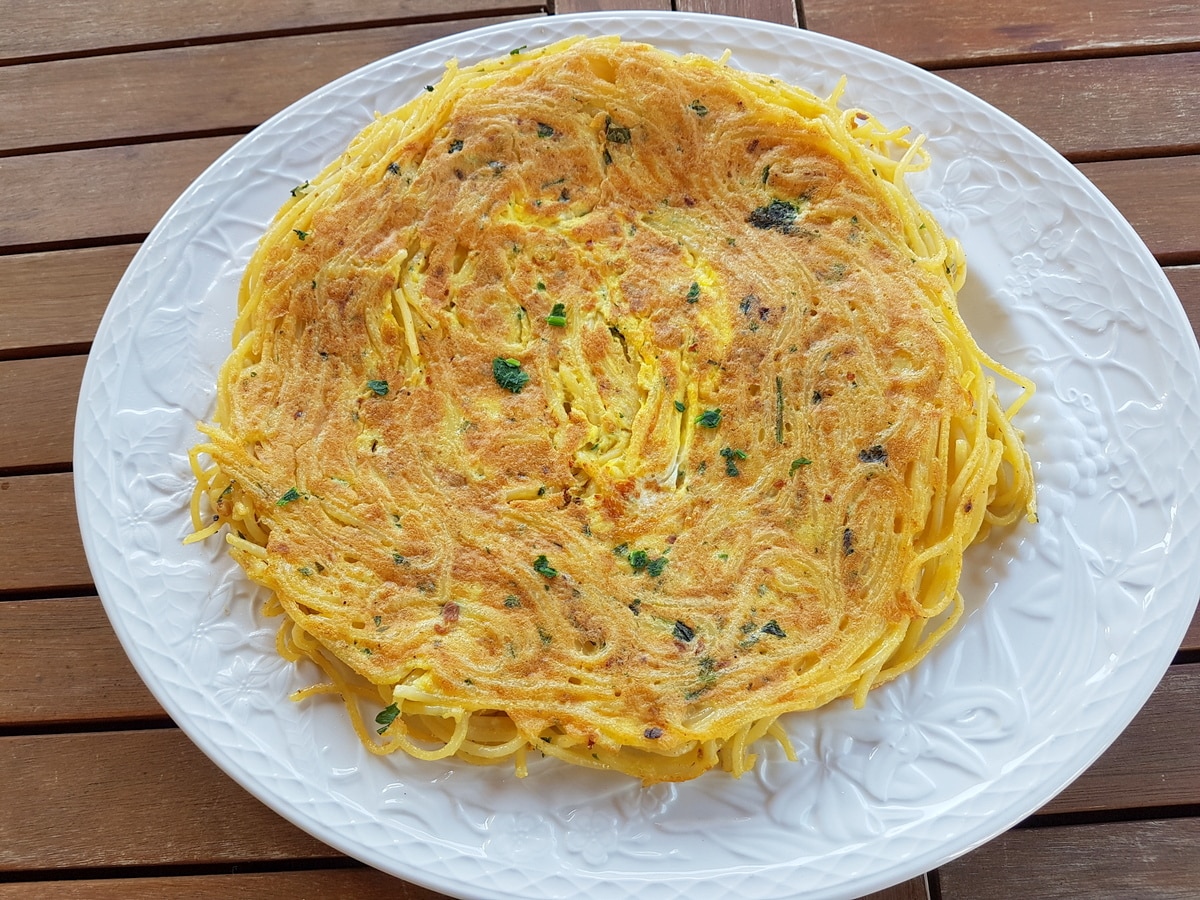 Pasta frittata on a white plate.