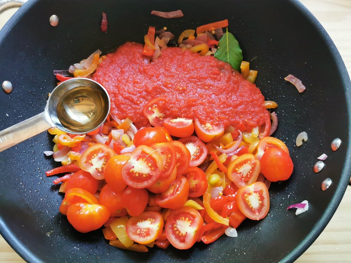 Tomatoes and a bay leaf added to the pan.