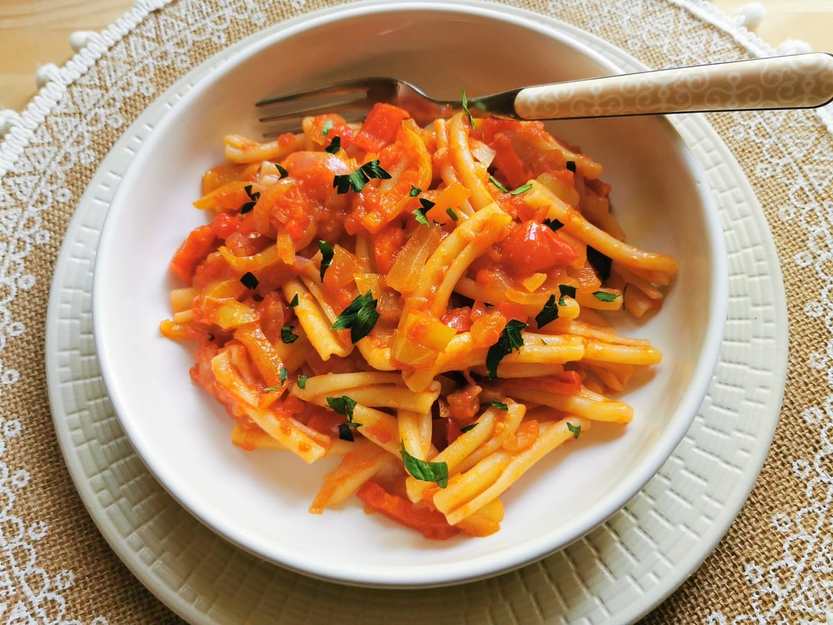 Pasta alla peperonata (sweet pepper sauce) in a bowl with a fork.